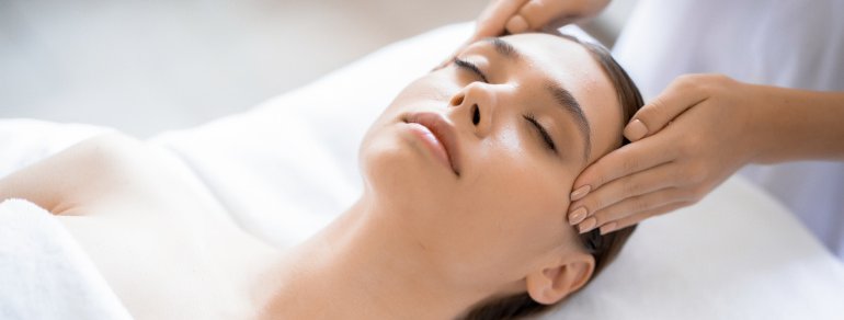 Frau erhält Schläfenmassage