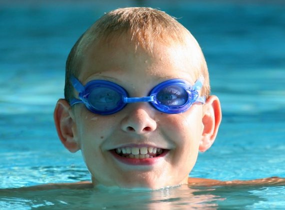 Kind mit Schwimmbrille im Wasser