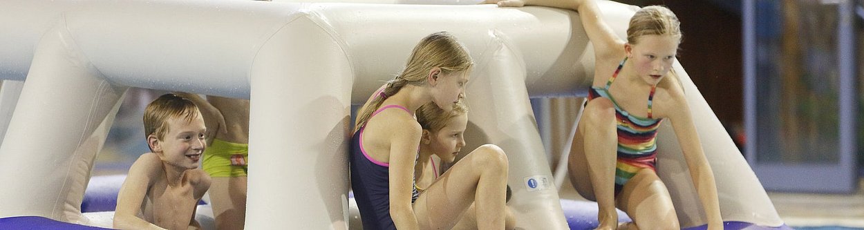 Kinder spielen auf dem Wasserparcours