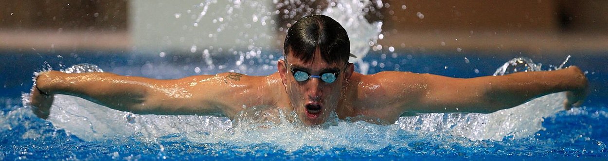 Schwimmer beim Schmetterlingsschwimmen mit ausgestreckten Armen