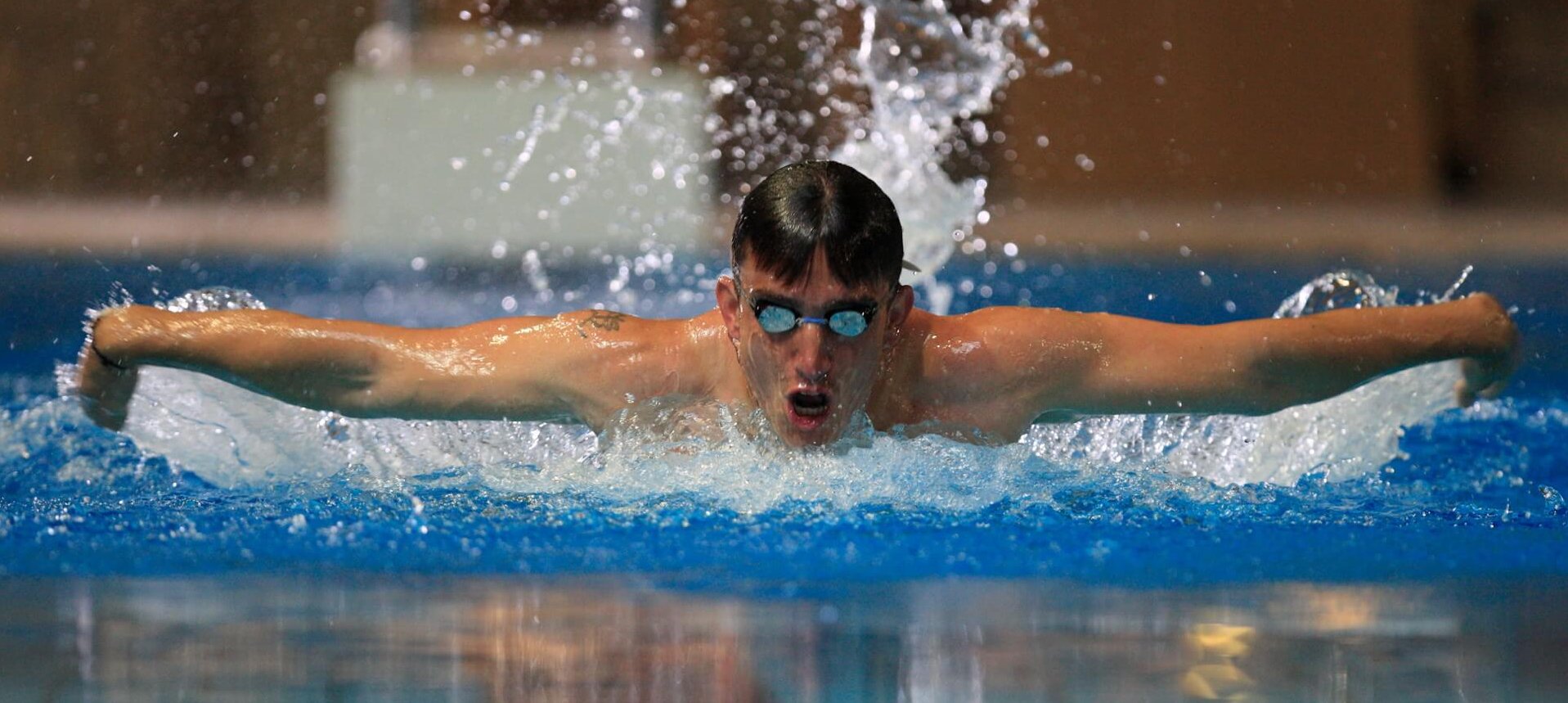 Swimmer doing butterfly stroke with arms outstretched