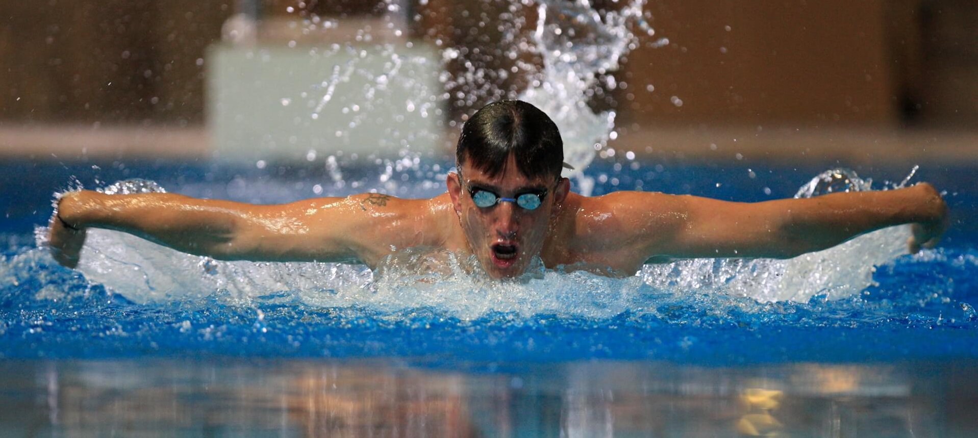 Schwimmer beim Schmetterlingsschwimmen mit ausgestreckten Armen