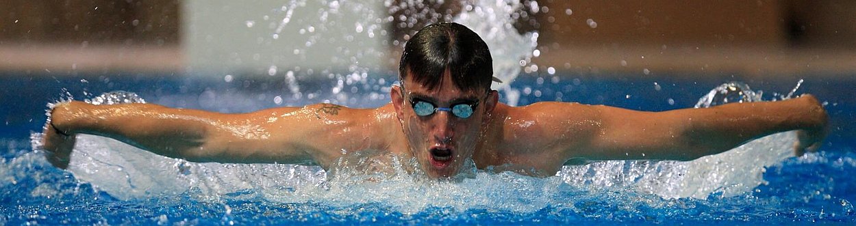 Swimmer doing butterfly stroke with arms outstretched