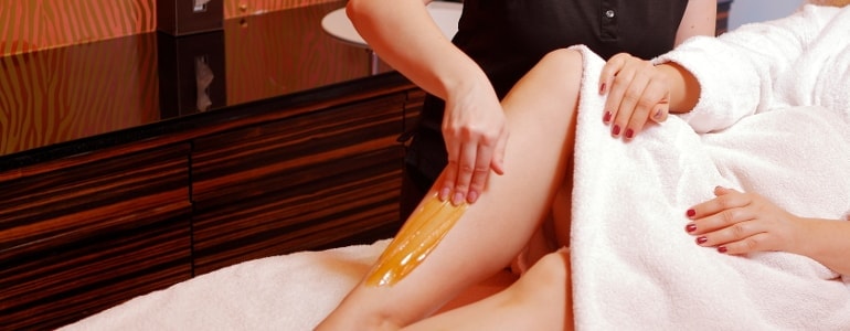 Body-Sugaring wird angewendet auf einem Bein